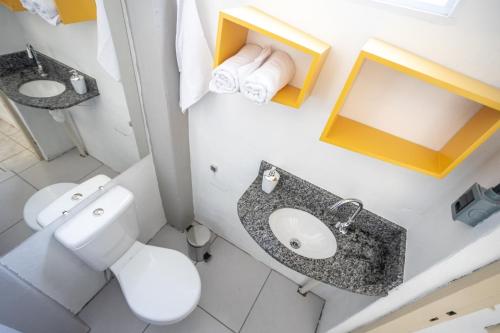 a bathroom with a toilet and a sink and a mirror at Apartamento no centro com estacionamento in Santa Maria