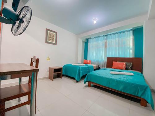 a room with two beds and a desk in it at Hotel Señor de Sipán in Chiclayo