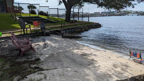 a group of chairs sitting on the shore of a body of water at Pirates Bay B303 in Fort Walton Beach