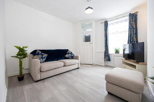 een woonkamer met een bank en een tv bij Manor Terrace Retreat in Accrington