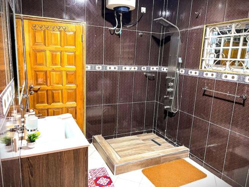 y baño con ducha y lavamanos. en Maryluxe Stays 6Bd villa, West hills, Accra Ghana, en Foso