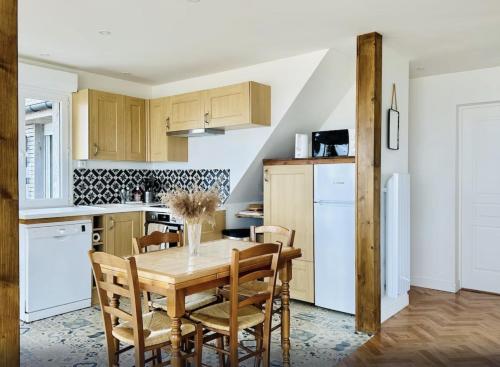 - une cuisine avec une table et des chaises en bois dans l'établissement Villa des Marées, à Asnelles