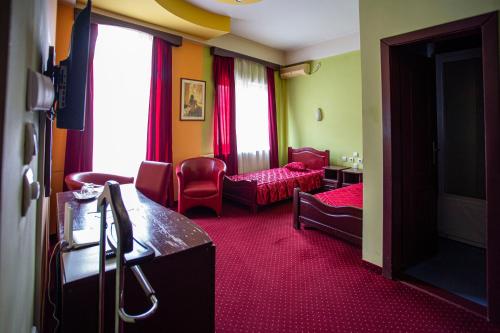 a hotel room with a living room with red carpet at B&B Vila Tamaris in Zaječar