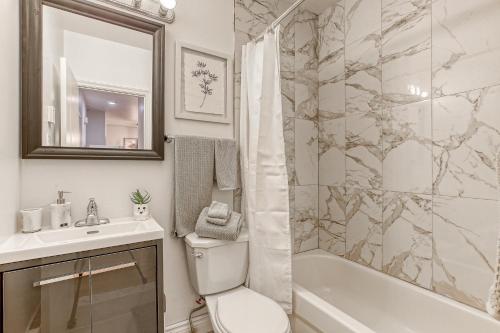 a bathroom with a toilet and a sink and a shower at Montreal Boutique Suites in Montréal