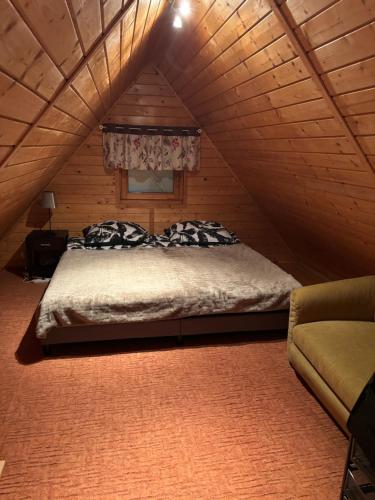 ein Schlafzimmer mit einem Bett im Dachgeschoss in der Unterkunft Domek w Górkach in Górki Wielkie