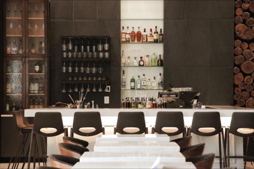 a bar with chairs and a counter with wine bottles at TRYP by Wyndham Savannah in Savannah