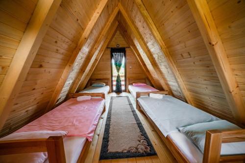 a room with three beds in a wooden attic at Una Relax in Bosanski Novi