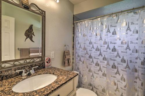 a bathroom with a sink and a shower curtain at Colorful Canalfront Merritt Island Home Gas Grill in Merritt Island