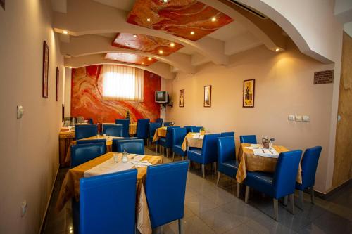 B&B Vila Tamaris في زاييتشار: غرفة طعام مع كراسي وطاولات زرقاء