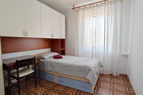 a small bedroom with a bed and a desk at Altana Rooms Apartment in Koper