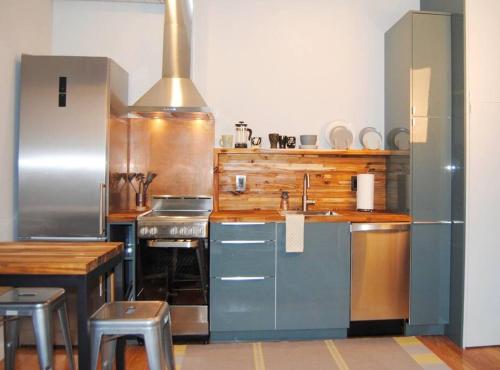 a kitchen with stainless steel appliances and a table at Trendy Studio in Prime South Philly Neighborhood in Philadelphia