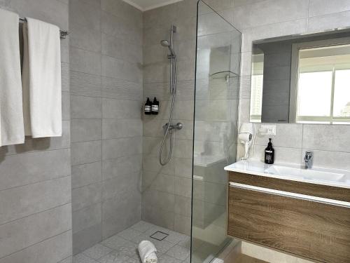 a bathroom with a shower and a sink at AmazINN Places Coco del Mar Seaview II in Panama City