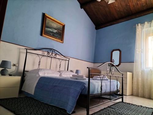 a bedroom with a bed with a blue wall at Casa vacanze Antonella in Oristano