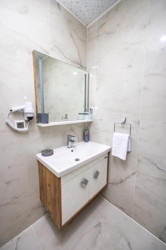 a bathroom with a sink and a mirror at Cihan Bey Otel Belek in Belek