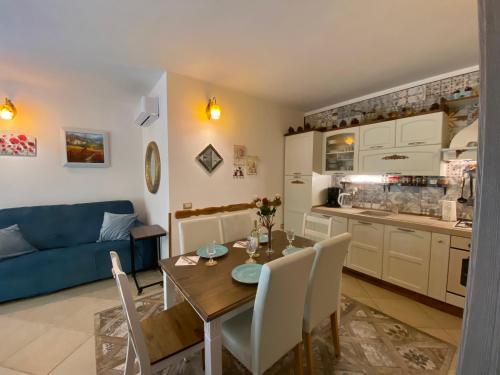 a kitchen and living room with a table and a blue couch at Residenza I Ginepri in Domus de Maria