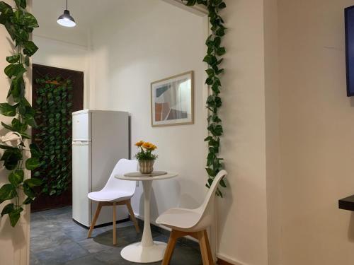 uma cozinha com uma mesa, 2 cadeiras e um frigorífico em Charming House in Central Athens em Atenas