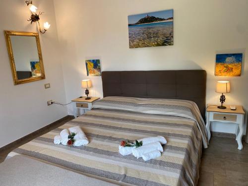 a bedroom with a bed and two towels at Residenza I Ginepri in Domus de Maria