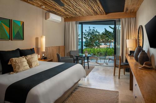 a hotel room with a bed and a living room at Alea Tulum in Tulum