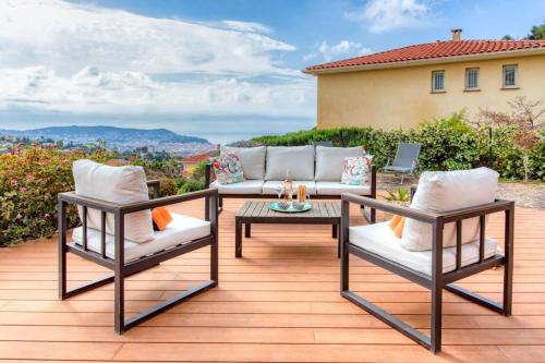a patio with a couch and chairs on a deck at Oliveraie Furnished villa in Nice