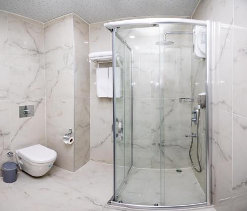 a bathroom with a shower and a toilet at Cihan Bey Otel Belek in Belek
