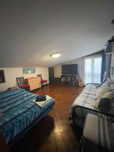 1 dormitorio con 2 camas y TV. en CineMaHouse TerraMare - 300m Beach & MaxiTV & WiFi, en Santa Marinella