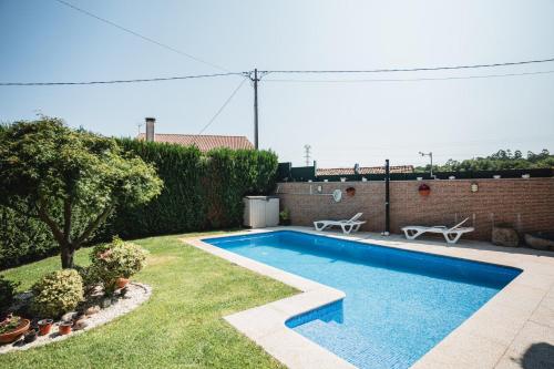 a swimming pool in the yard of a house at Chalet Os castaños in Caldas de Reis