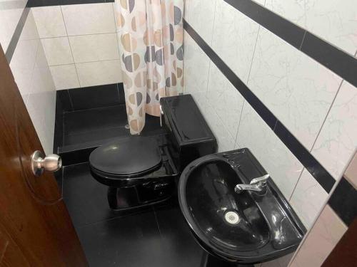 a bathroom with a black toilet and a sink at Independiente Minidepa Yanahuara in Yanahuara