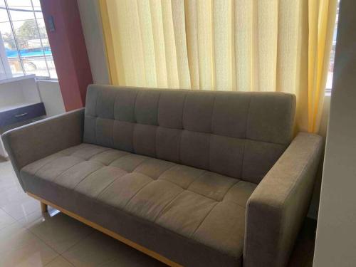 un sofá en una sala de estar con ventana en Independiente Minidepa Yanahuara en Yanahuara
