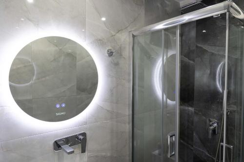 a bathroom with a shower with a round mirror at SKG Modernity Studio in Thessaloniki