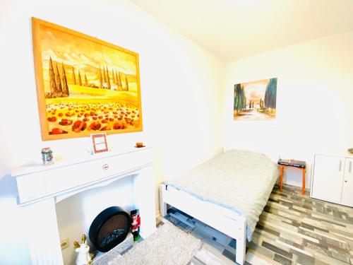 um quarto com lareira e uma pintura na parede em Welcome to Messe! Two-bedroom SmartApartment &Balcony em Hanôver
