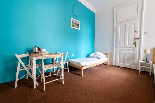a room with a table and a blue wall at Trzy Kafki Private Rooms in Kraków