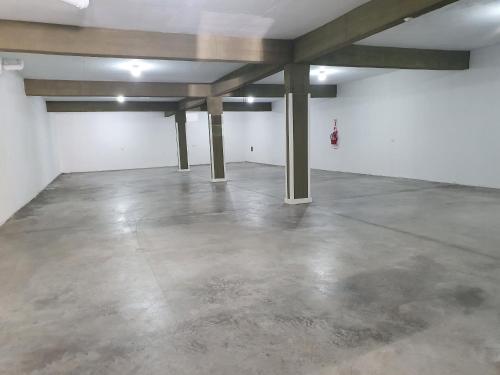 an empty garage with concrete floors and wooden beams at Colores Rio Cuarto in Río Cuarto