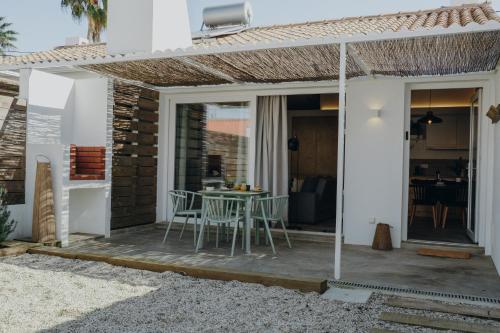 a patio with a table and chairs on it at Relaxing House Faro - Rogil 4 in Aljezur