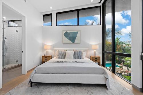 una camera da letto con un letto grande e grandi finestre di Villa Panaroma a Hallandale Beach