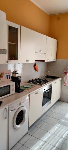 a kitchen with white cabinets and a stove and a dishwasher at "Casa Sofia" appartamento Raffalda ZONA CLINICA in Piacenza