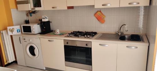 a kitchen with a stove and a washing machine at "Casa Sofia" appartamento Raffalda ZONA CLINICA in Piacenza