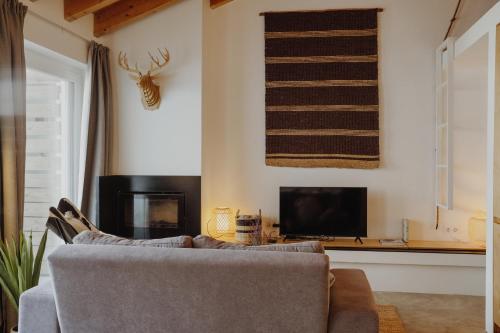 a living room with a couch and a tv at Relaxing House Faro - Rogil 4 in Aljezur