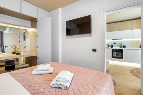 una camera da letto con un letto con due asciugamani sopra di Sandy Breeze - Jacuzzi & Sauna Infinity Resort a Mamaia Nord - Năvodari