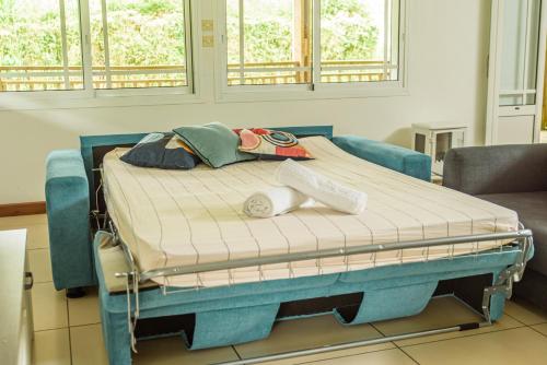 Una cama de hospital en una habitación con dos ventanas en Ti Kaz Bibass en La Plaine-des-Palmistes