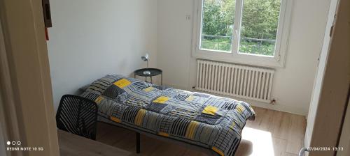 une petite chambre avec un lit et une fenêtre dans l'établissement Saint Brieuc sortie ville Logement dans maison année 1970 disposant de 5 chambres 6 personnes adultes ou enfants, à Saint-Brieuc