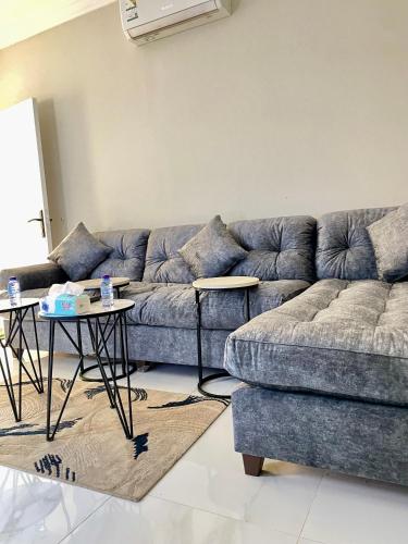 a living room with a couch and two tables at Smart Entry Apartment in Riyadh