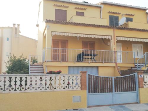 a yellow house with a fence and a balcony at Casa a 85 metros playa 158 m2 4 dorm WIFI in Oliva