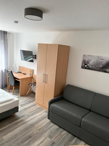 ein Wohnzimmer mit einem Sofa und einem Schreibtisch in der Unterkunft Pension im Wirtshaus Himberg in Bad Honnef am Rhein