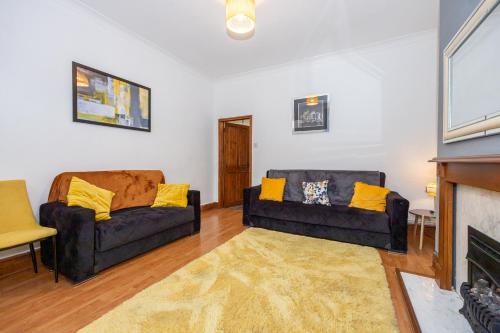 a living room with two couches and a fireplace at Cosy Two bedroom Terrace Blackburn in Cherry Tree