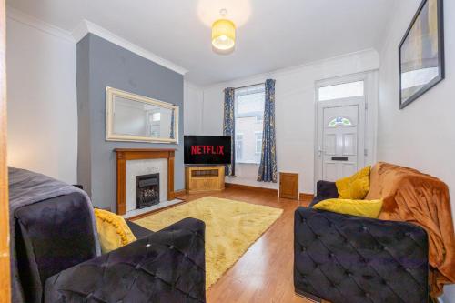 a living room with a couch and a fireplace at Cosy Two bedroom Terrace Blackburn in Cherry Tree