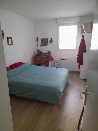une chambre avec un grand lit et une fenêtre dans l'établissement Appartement cosy et lumineux, à Marseille