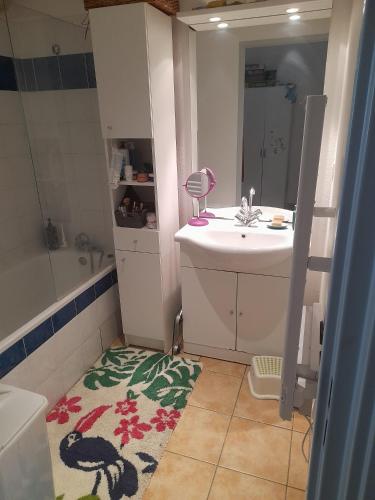 ein Badezimmer mit einem Waschbecken, einem WC und einem Spiegel in der Unterkunft Appartement cosy et lumineux in Marseille
