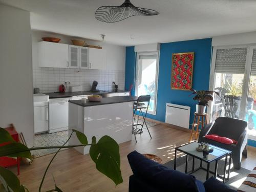eine Küche und ein Wohnzimmer mit blauen Wänden und einem Tisch in der Unterkunft Appartement cosy et lumineux in Marseille