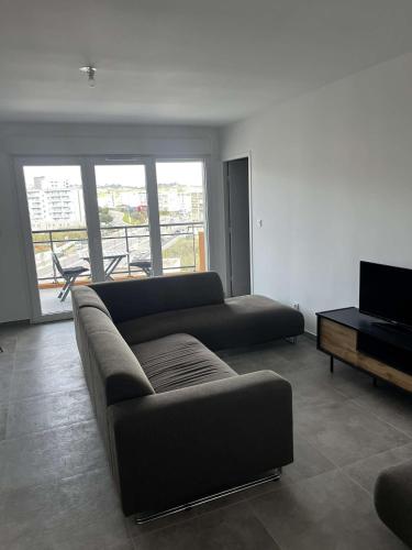 un salon avec un canapé et une télévision dans l'établissement Très beau T2, à Ajaccio