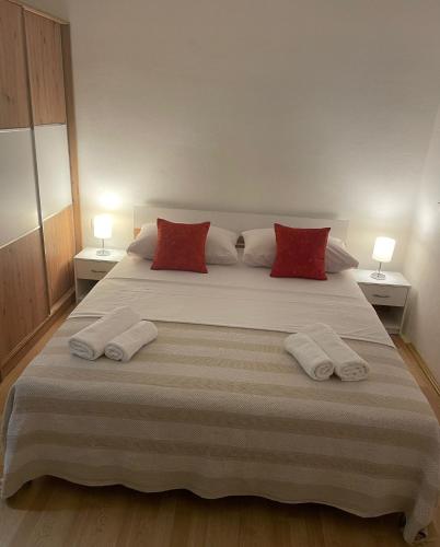 ein Schlafzimmer mit einem großen Bett mit roten Kissen in der Unterkunft GOKI near airport and city, sea view in Kaštel Sućurac